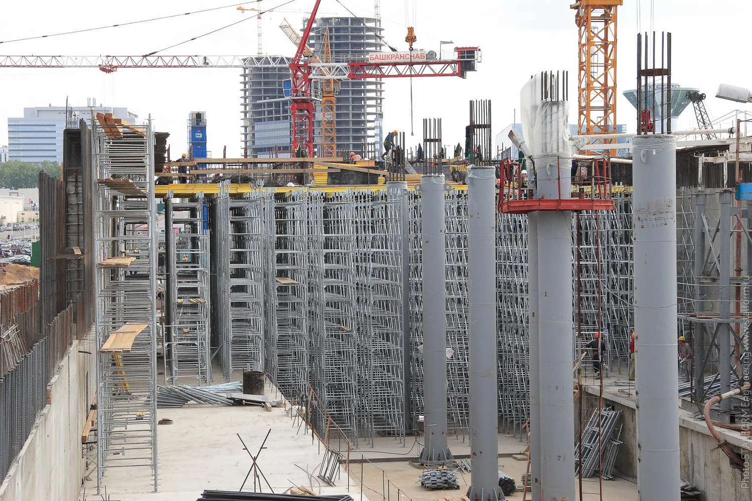 Steel frame shoring towers with horizontal members and diagonal bracing supporting concrete slab formwork